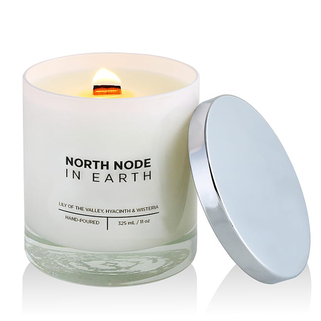 a lit up candle with the lid on its side and subtle glow of the orange light from the fire